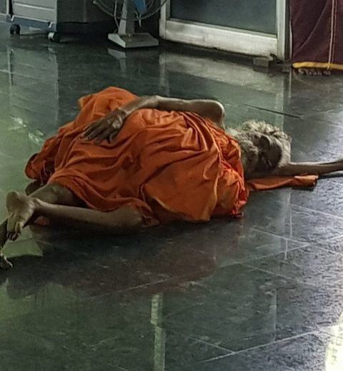 muoku podi swami laying on floor in meditation hall at sheshadri ashram
