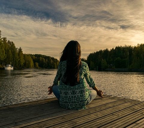 woman in meditation at lake